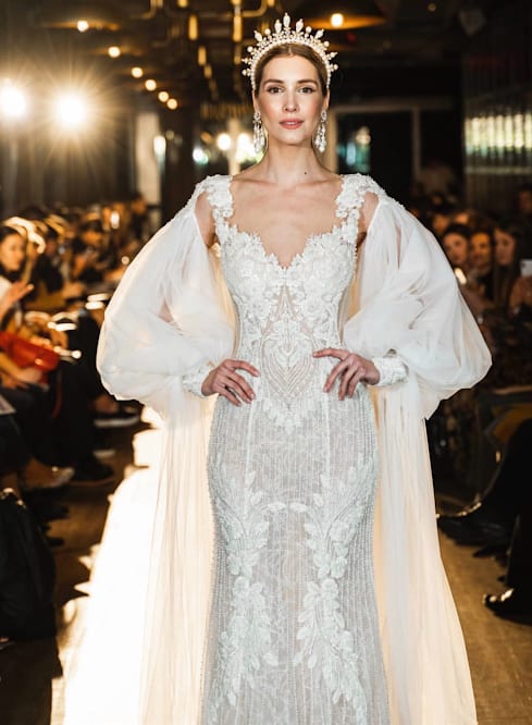 A runway model wearing an elegant bridal gown