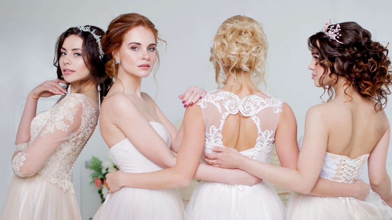 Four models wearing bridal gowns