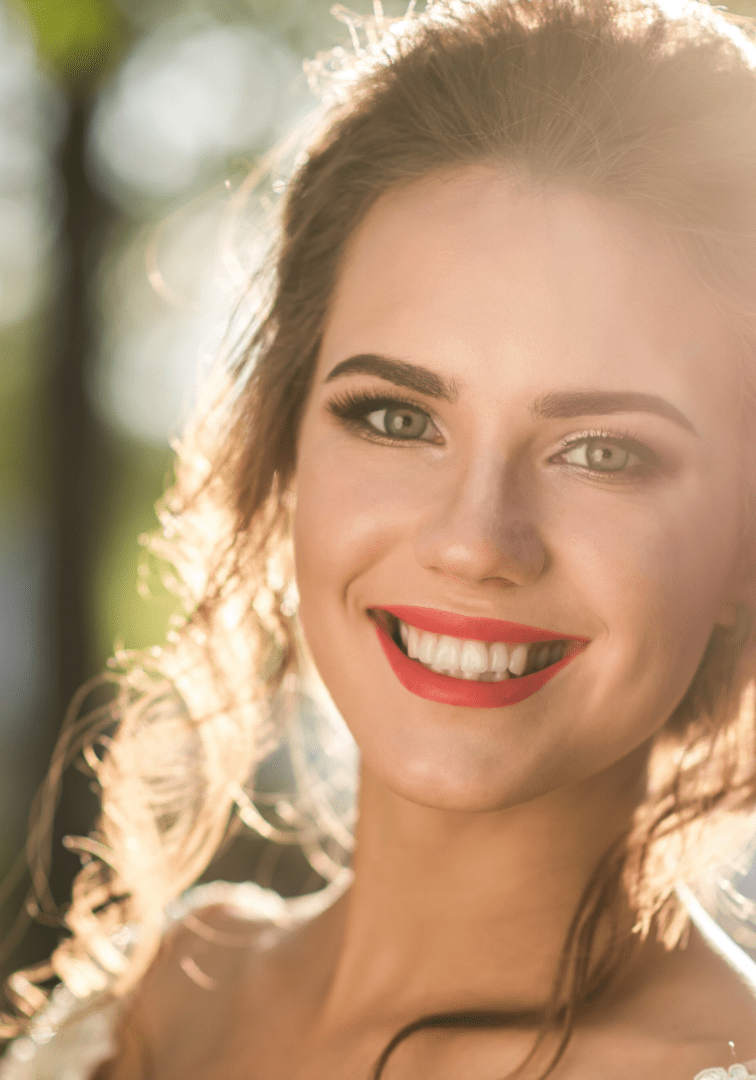 A woman with red lipstick smiles for the camera.