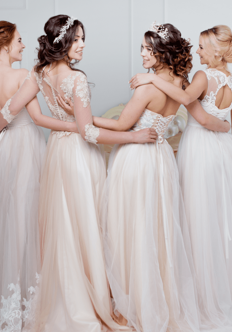 A group of women in long dresses hugging each other.